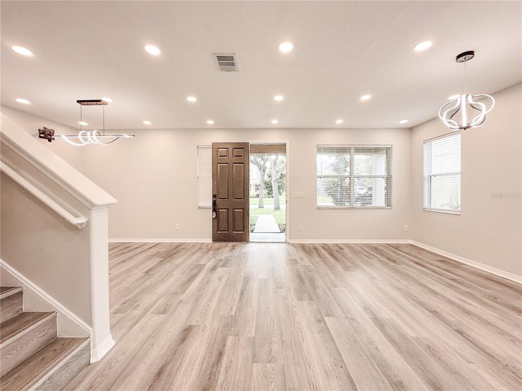 7322 Bridgeview Drive Wesley Chapel, FL 33545 - Photo 6 of 75 a view of an empty room with wooden floor and a window