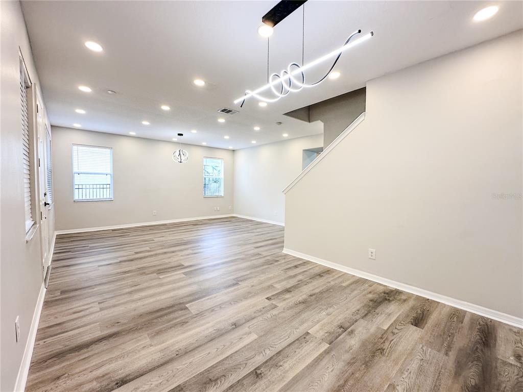 7322 Bridgeview Drive Wesley Chapel, FL 33545 - Photo 7 of 75 an empty room with wooden floor and windows