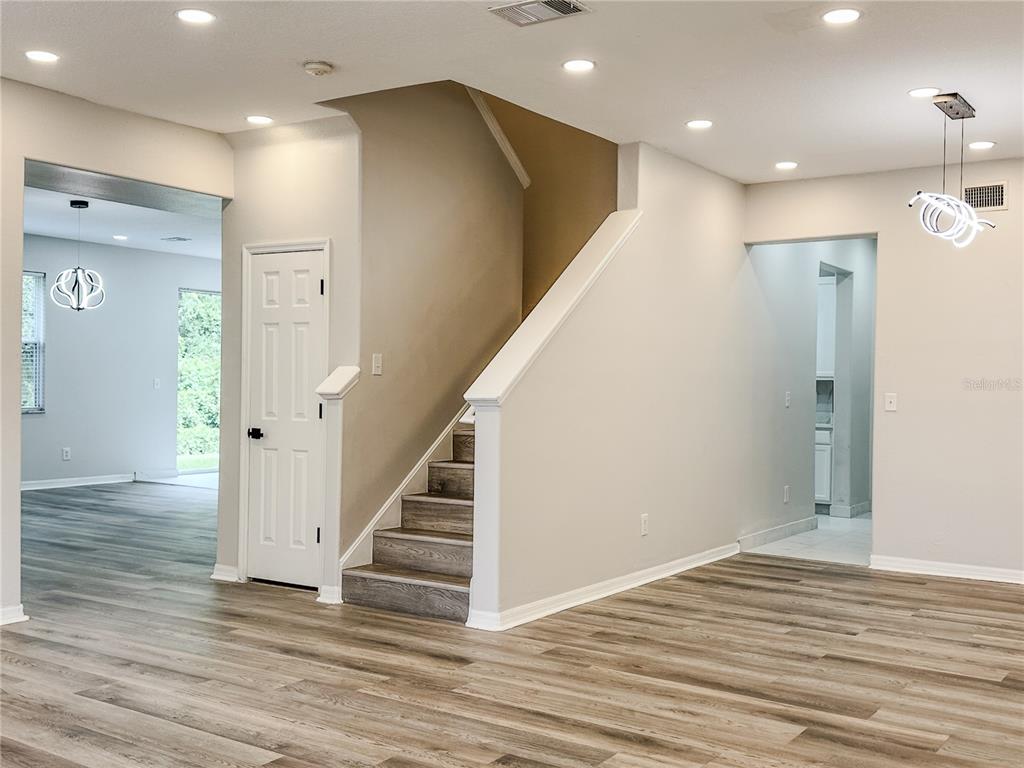 7322 Bridgeview Drive Wesley Chapel, FL 33545 - Photo 9 of 75 a view of a hallway with wooden floor and staircase