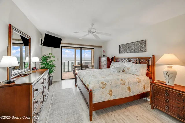 a spacious bedroom with a bed and wooden floor