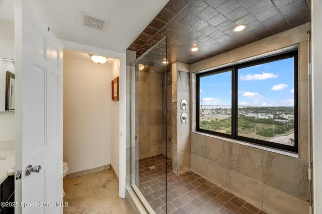 a spacious bedroom with a bed and a chandelier
