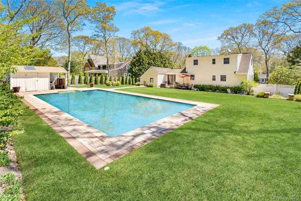 a view of an house with swimming pool and trees in the background