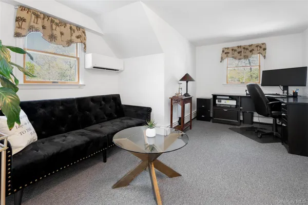 a living room with furniture a flat screen tv and a window