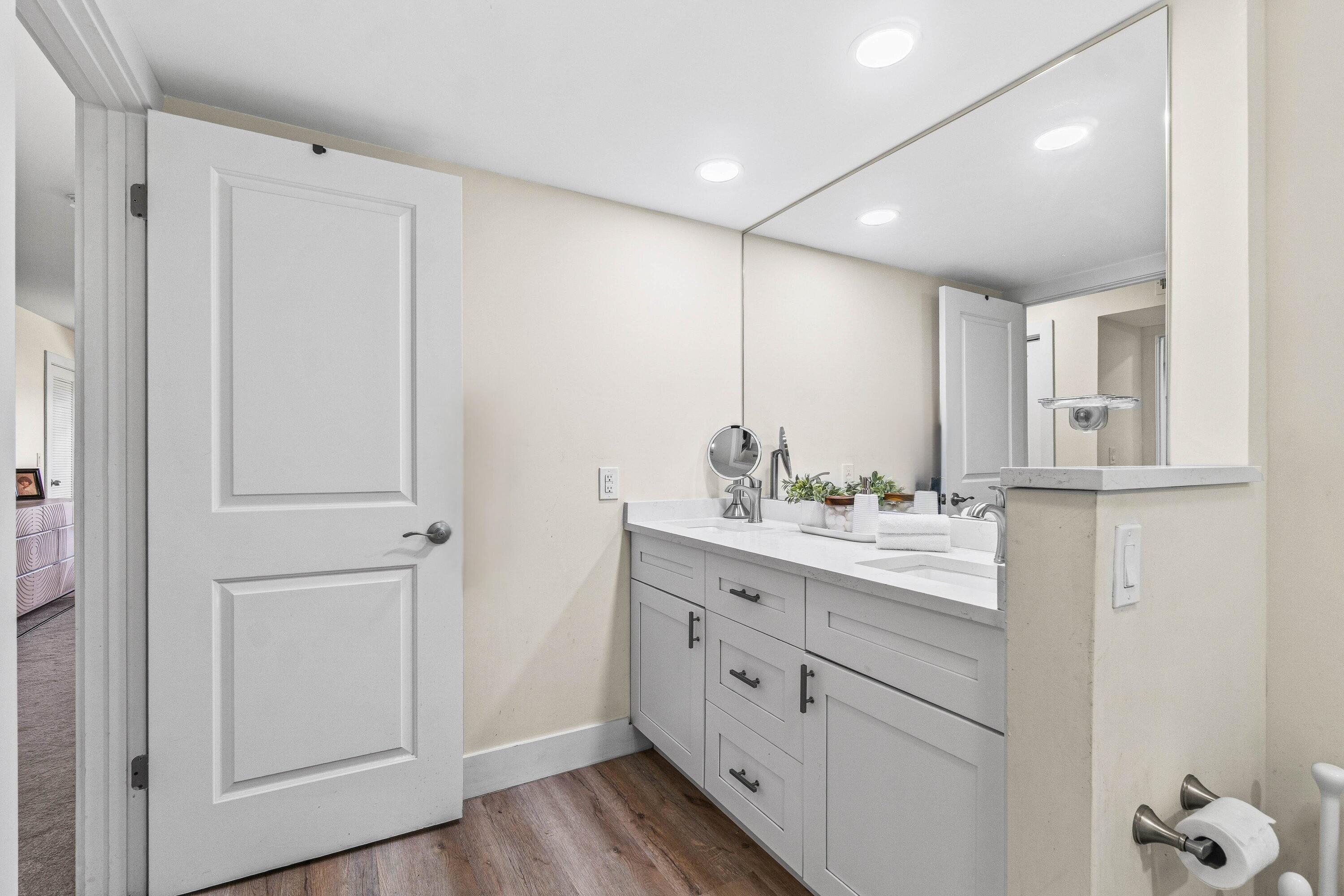 18 Stratford Drive, Unit E Boynton Beach, FL 33436 - Photo 16 of 49 a bathroom with a double vanity sink and a mirror