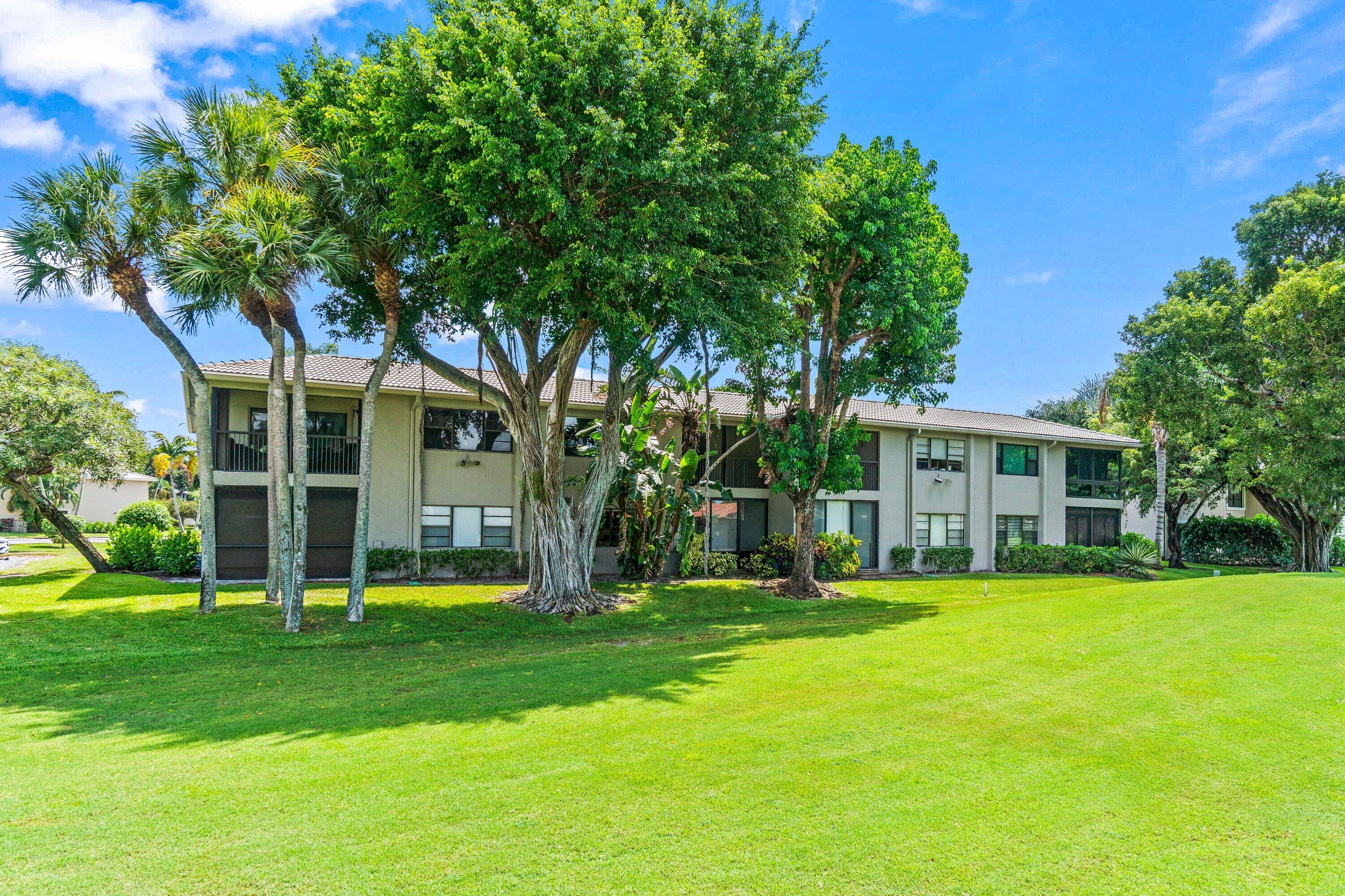 18 Stratford Drive, Unit E Boynton Beach, FL 33436 - Photo 21 of 49 a view of a house with a big yard and palm trees