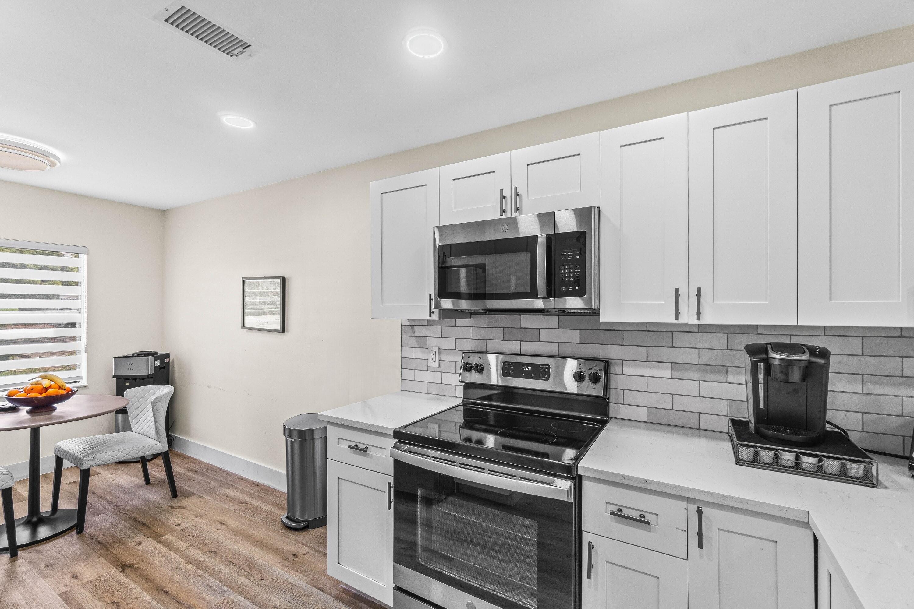 18 Stratford Drive, Unit E Boynton Beach, FL 33436 - Photo 2 of 49 a kitchen with stainless steel appliances a stove a microwave sink and cabinets
