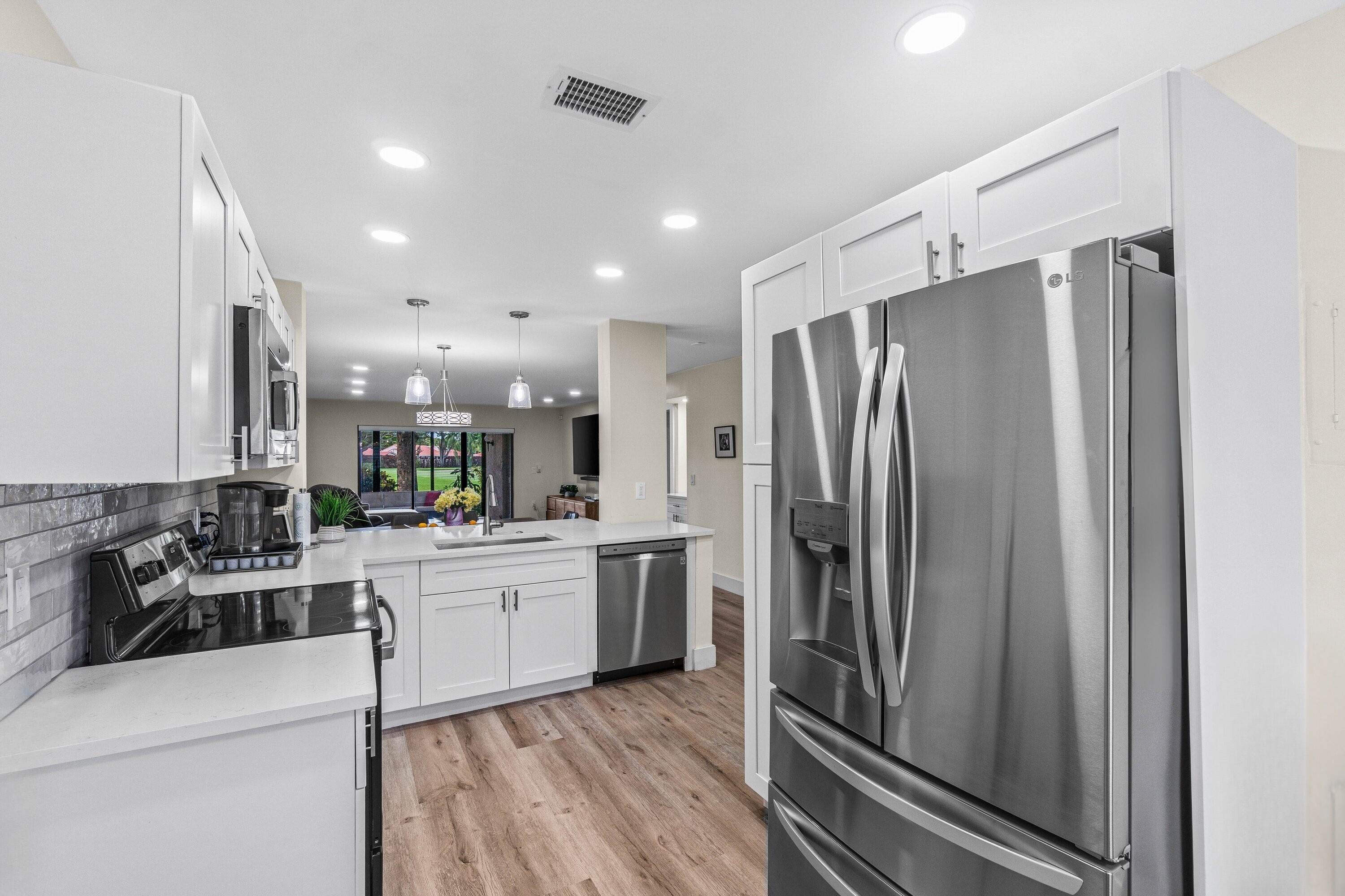 18 Stratford Drive, Unit E Boynton Beach, FL 33436 - Photo 3 of 49 a kitchen with a refrigerator and a sink