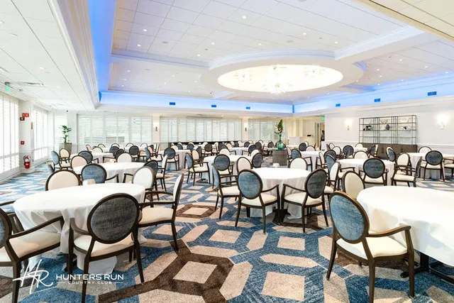 a very nice looking dining room with lots of chairs and chandelier