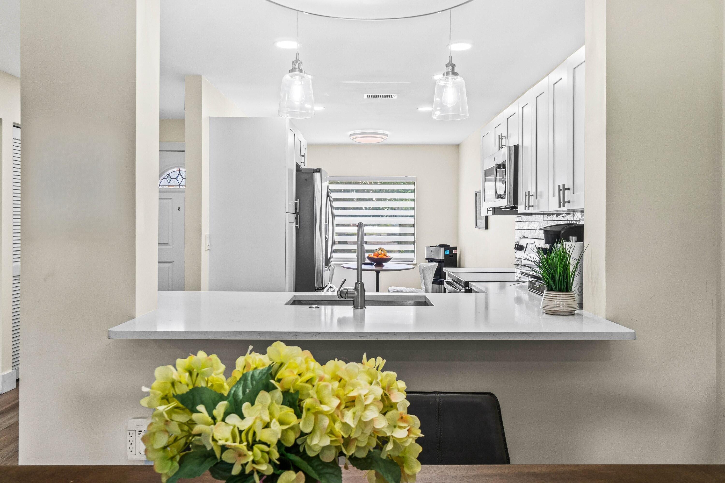18 Stratford Drive, Unit E Boynton Beach, FL 33436 - Photo 5 of 49 a white kitchen with a stove a sink and a window