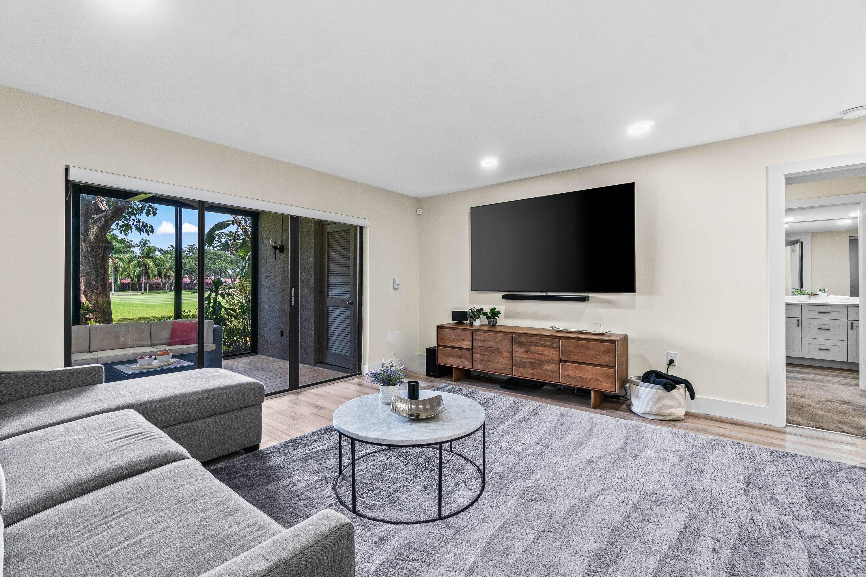 18 Stratford Drive, Unit E Boynton Beach, FL 33436 - Photo 8 of 49 a living room with furniture and a flat screen tv