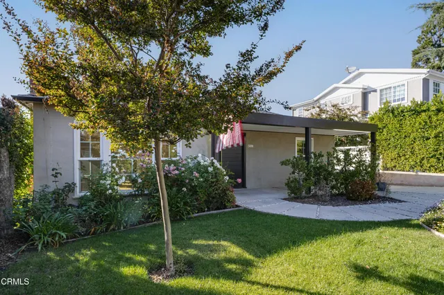 a view of a house with garden and a tree