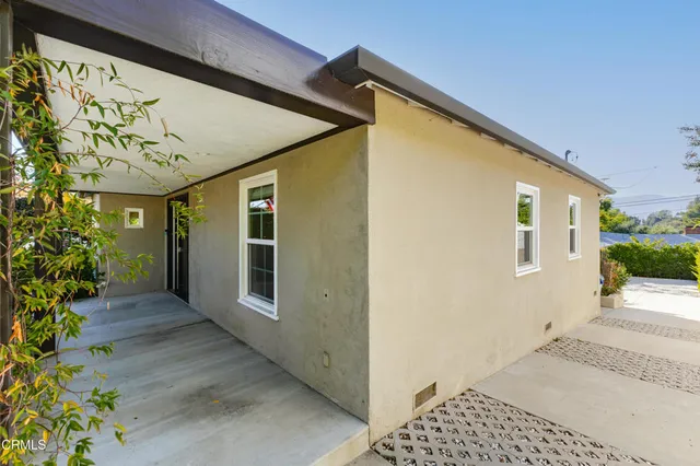 a front view of a house with plants