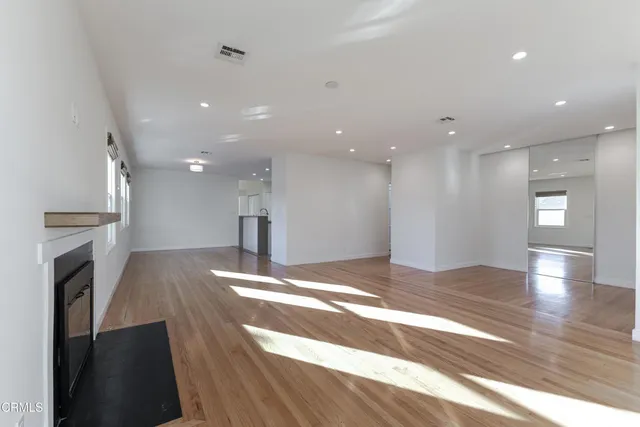 a view of an empty room and a kitchen