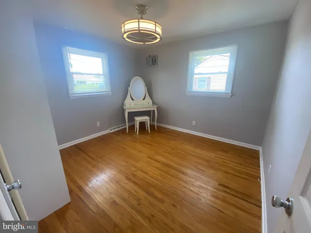 a view of a room with wooden floor and windows