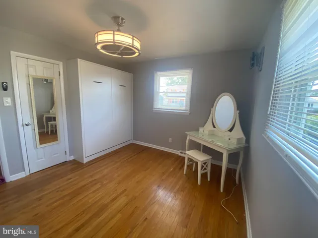 a view of a workspace room with wooden floor table and chair