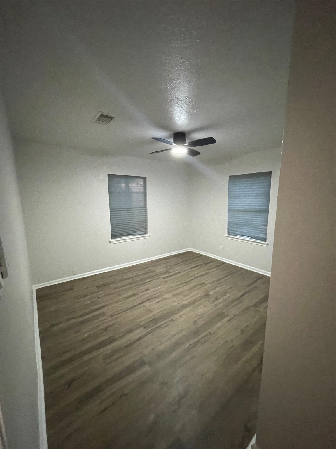 6003 Westover Street Houston, TX 77033 - Photo 14 of 19 an empty room with wooden floor and windows