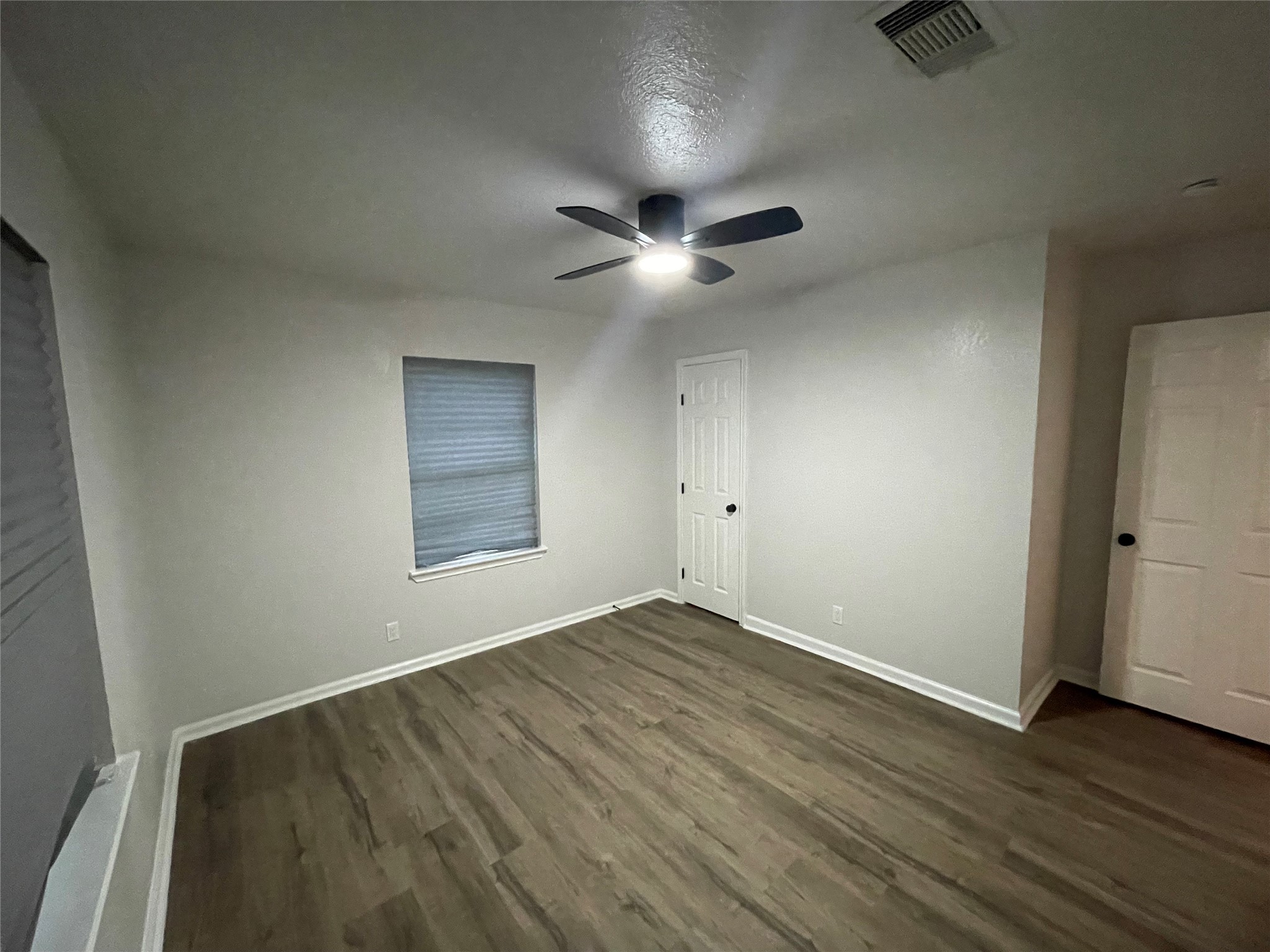6003 Westover Street Houston, TX 77033 - Photo 15 of 19 an empty room with wooden floor and windows