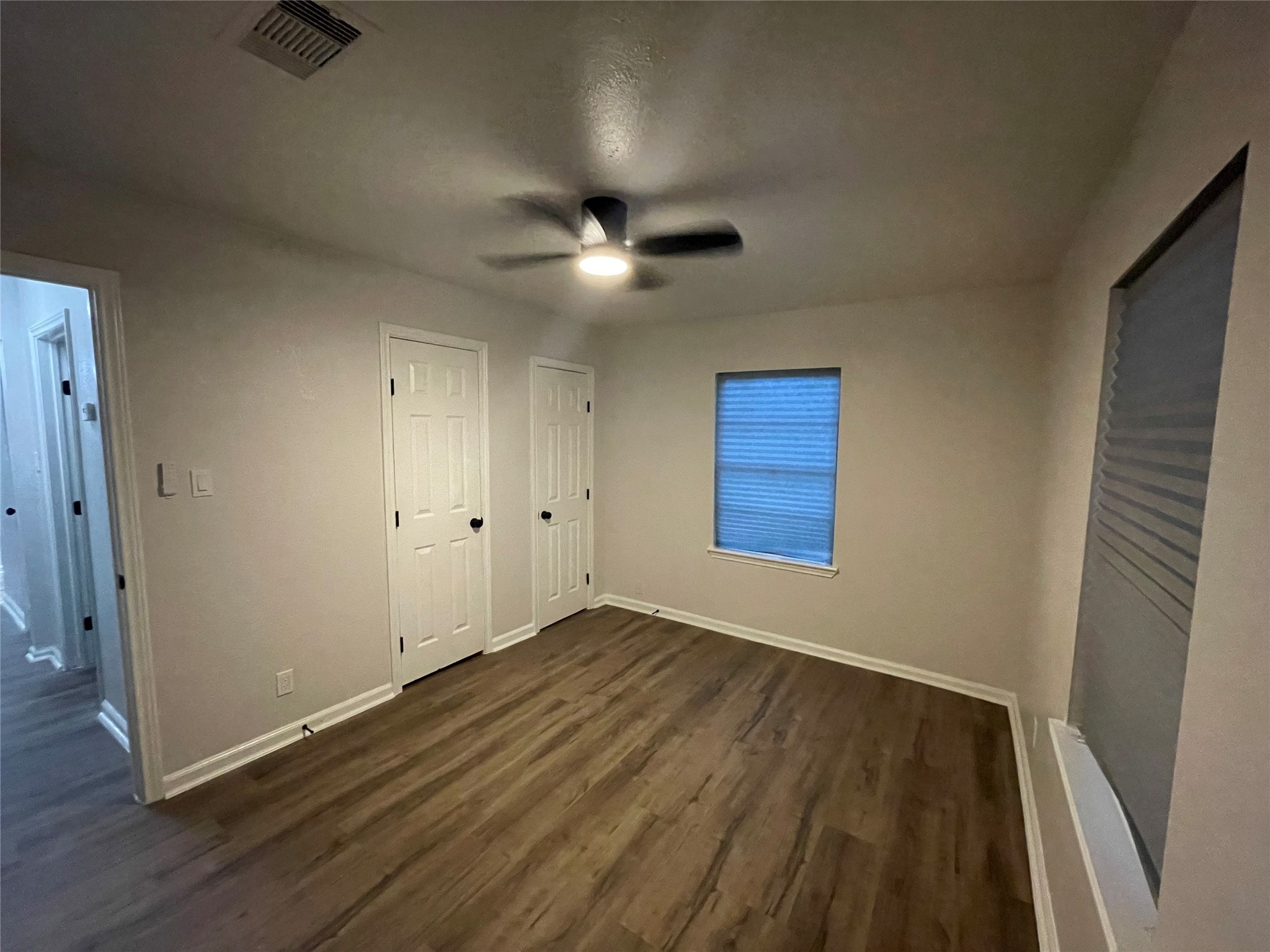 6003 Westover Street Houston, TX 77033 - Photo 16 of 19 an empty room with wooden floor chandelier fan and windows