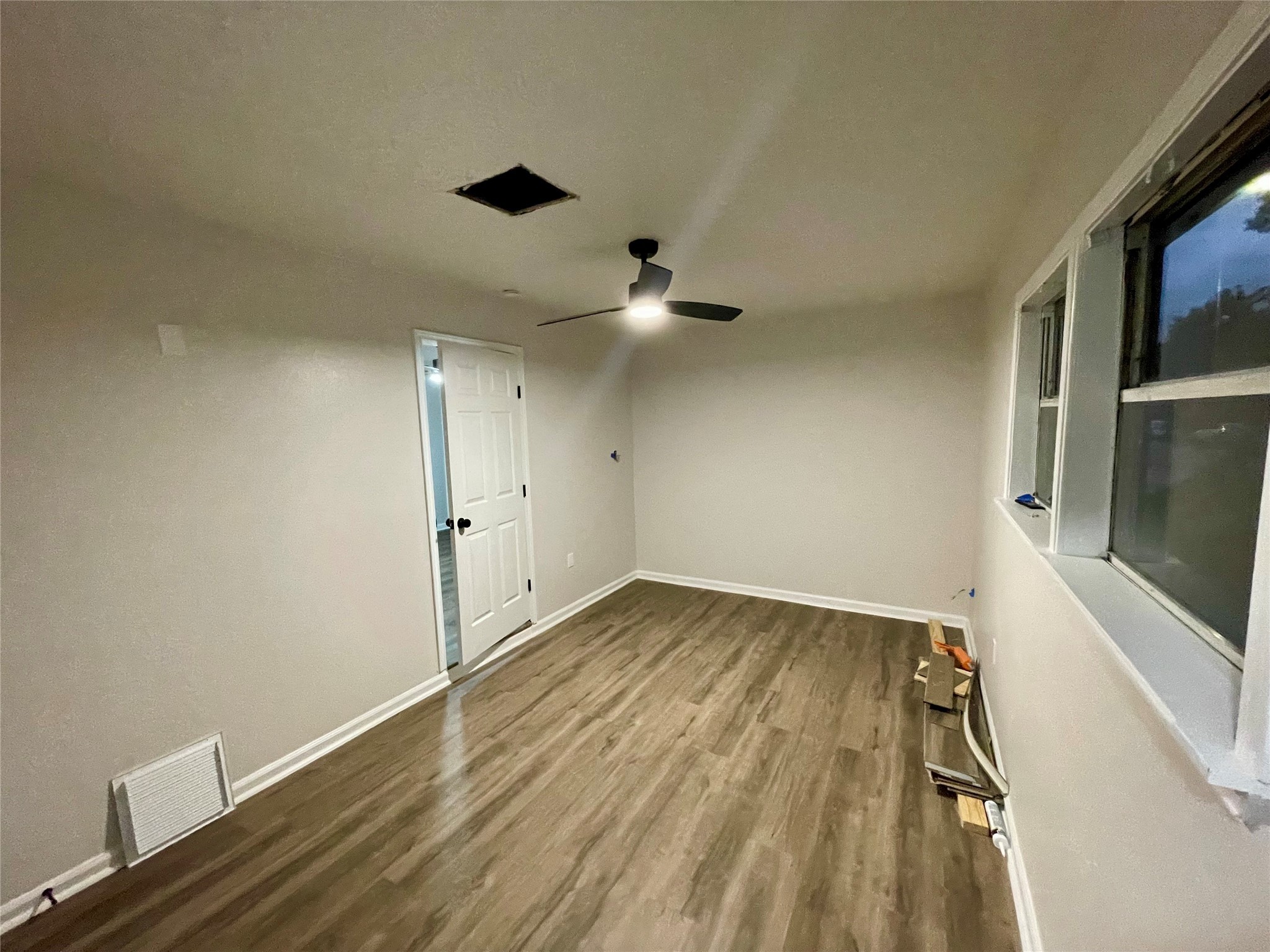 6003 Westover Street Houston, TX 77033 - Photo 19 of 19 an empty room with wooden floor and windows