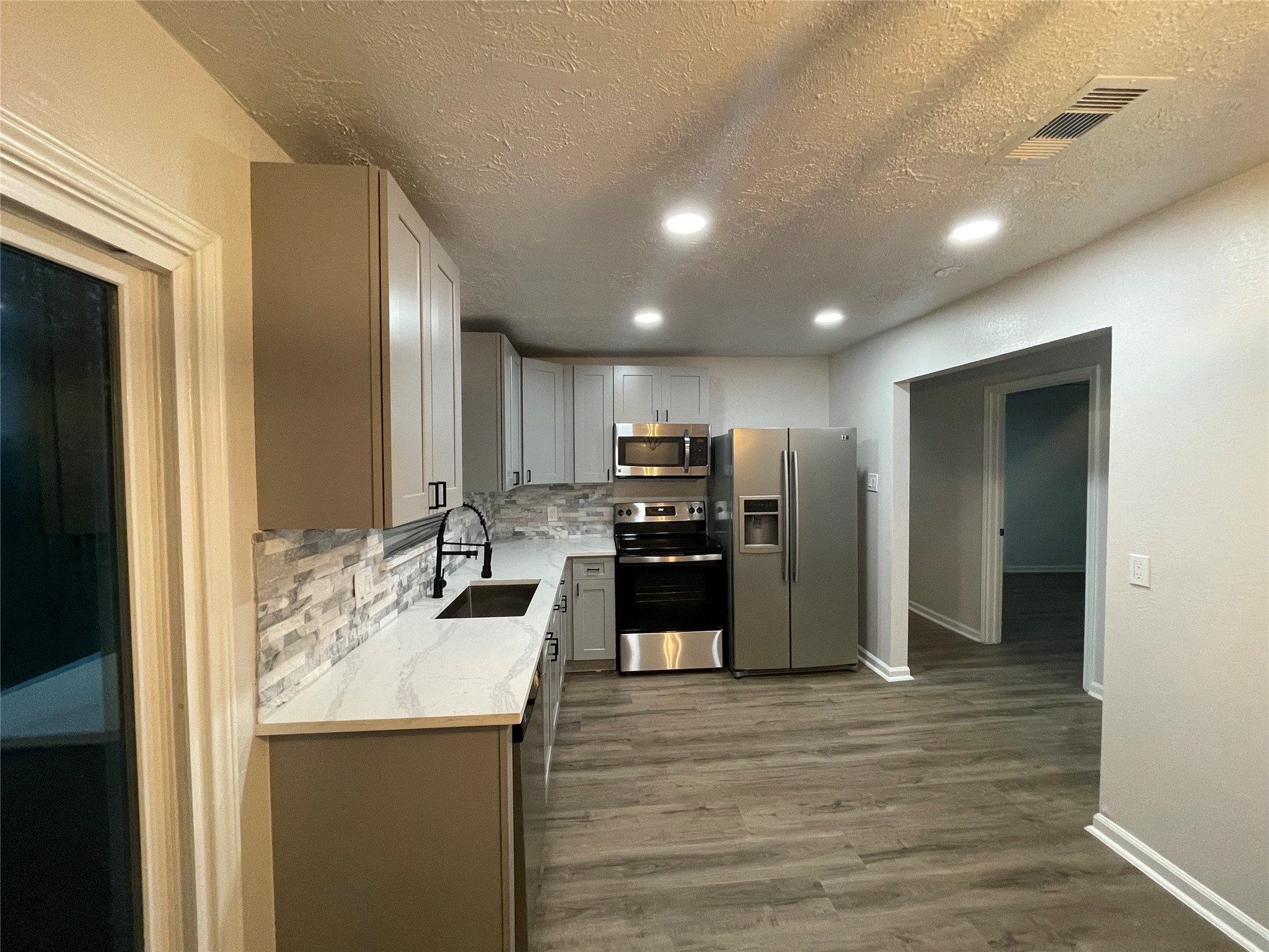 6003 Westover Street Houston, TX 77033 - Photo 4 of 19 a kitchen with stainless steel appliances kitchen island granite countertop a refrigerator and a sink