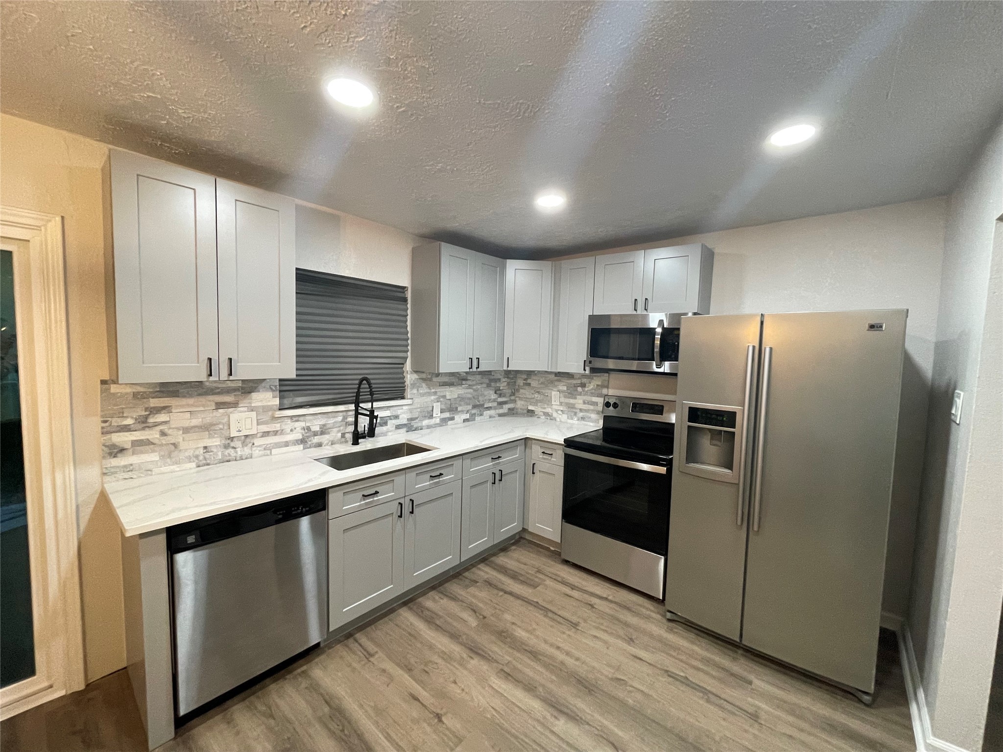 6003 Westover Street Houston, TX 77033 - Photo 5 of 19 a kitchen with a sink stainless steel appliances and white cabinets