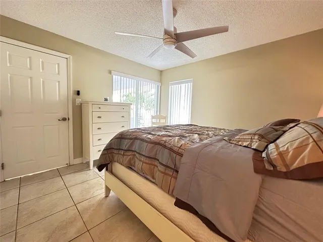 a bedroom with a bed and a ceiling fan