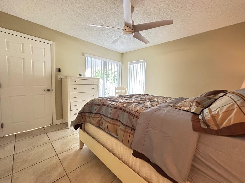 17801 North Bay Road, Unit 212 Sunny Isles Beach, FL 33160 - Photo 37 of 48 a bedroom with a bed and a ceiling fan