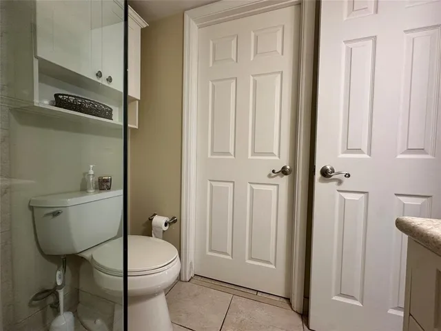 a bathroom with a granite countertop toilet a sink and a mirror