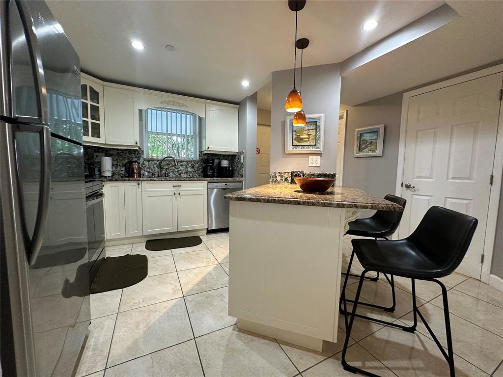 17801 North Bay Road, Unit 212 Sunny Isles Beach, FL 33160 - Photo 9 of 48 a kitchen with stainless steel appliances kitchen island granite countertop a sink and cabinets