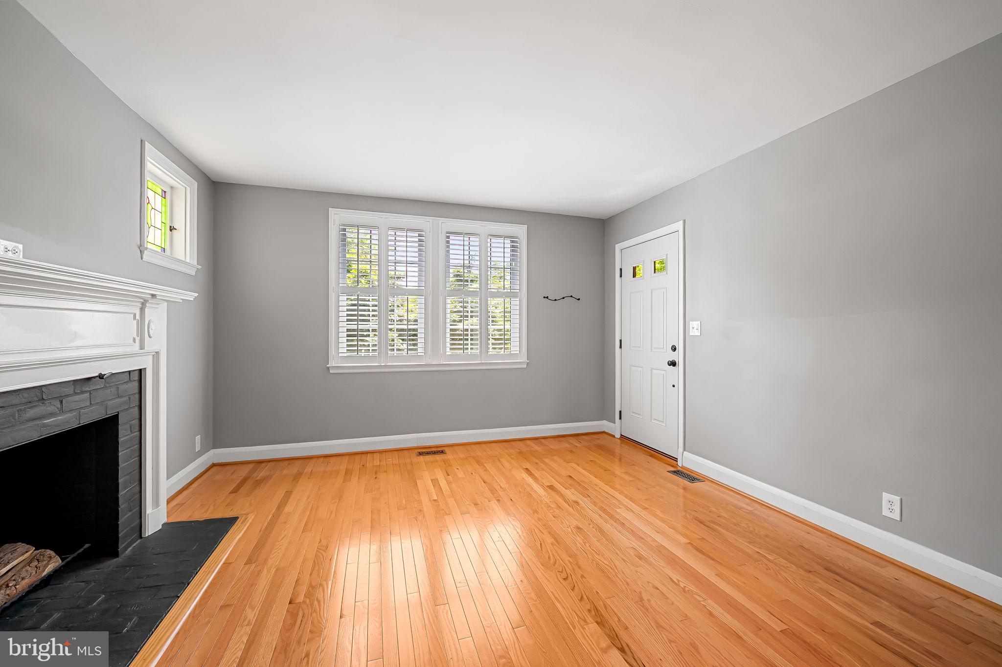 526 Dunkirk Road Baltimore, MD 21212 - Photo 6 of 44 a view of empty room with wooden floor and fireplace
