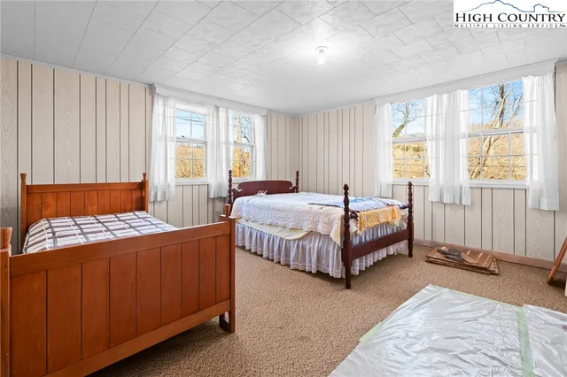 a bedroom with a bed lamp and a large window