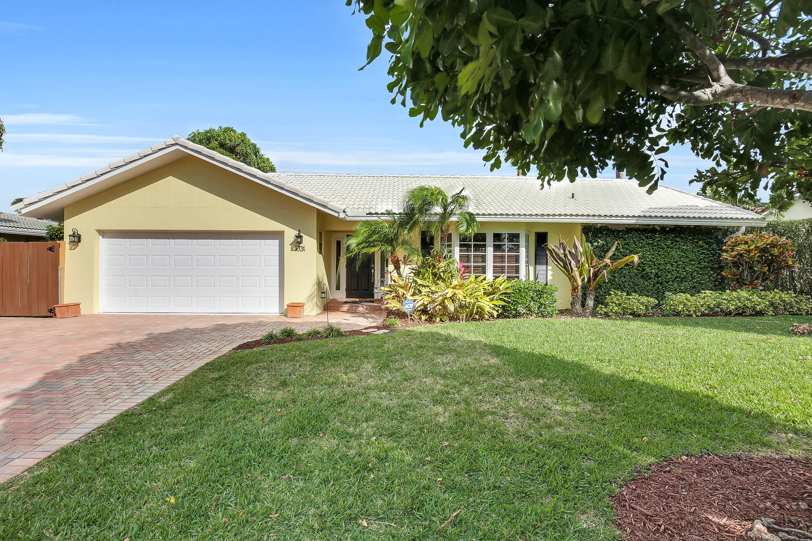 a front view of a house with a yard and green space