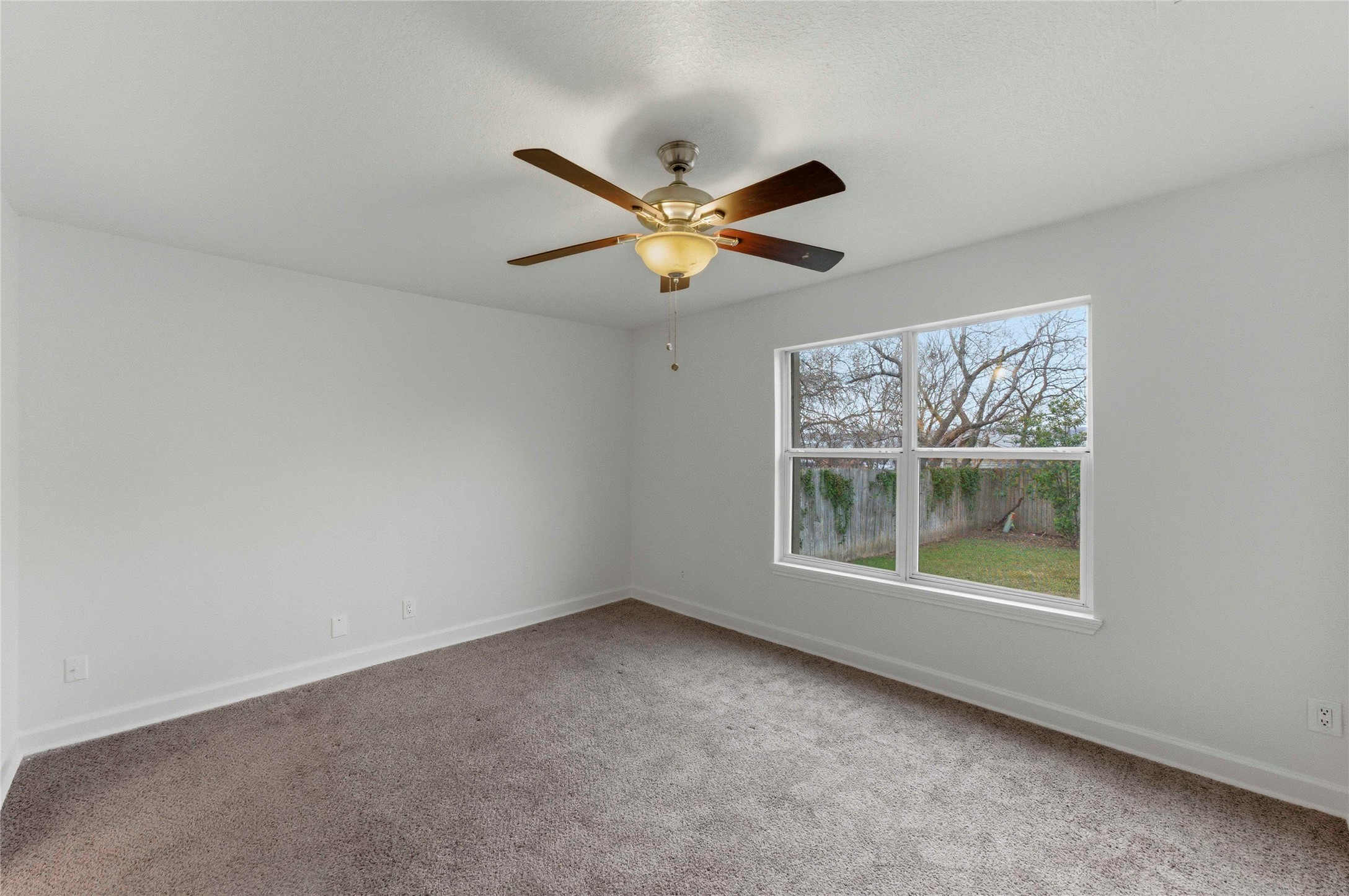 1909 Crooked Lane Austin, TX 78741 - Photo 13 of 25 Unfurnished room with light carpet and ceiling fan