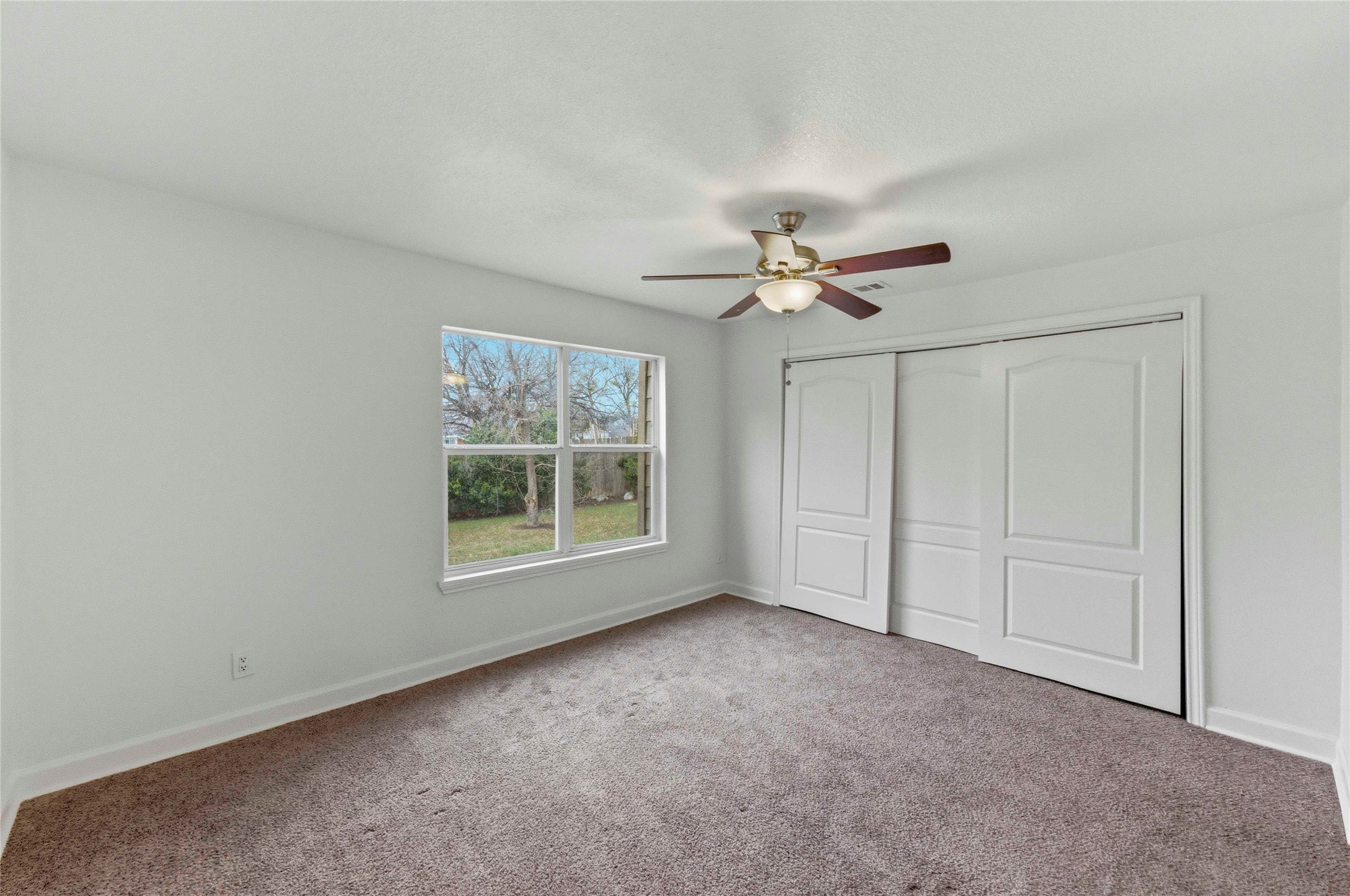 1909 Crooked Lane Austin, TX 78741 - Photo 14 of 25 Unfurnished bedroom featuring carpet floors, ceiling fan, and a closet