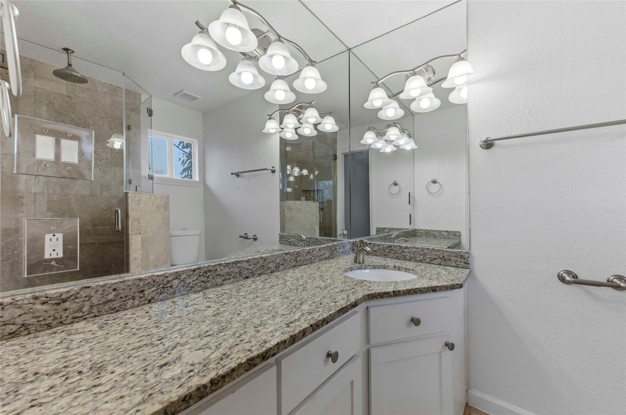 1909 Crooked Lane Austin, TX 78741 - Photo 15 of 25 Bathroom featuring a shower stall, vanity, and a textured wall
