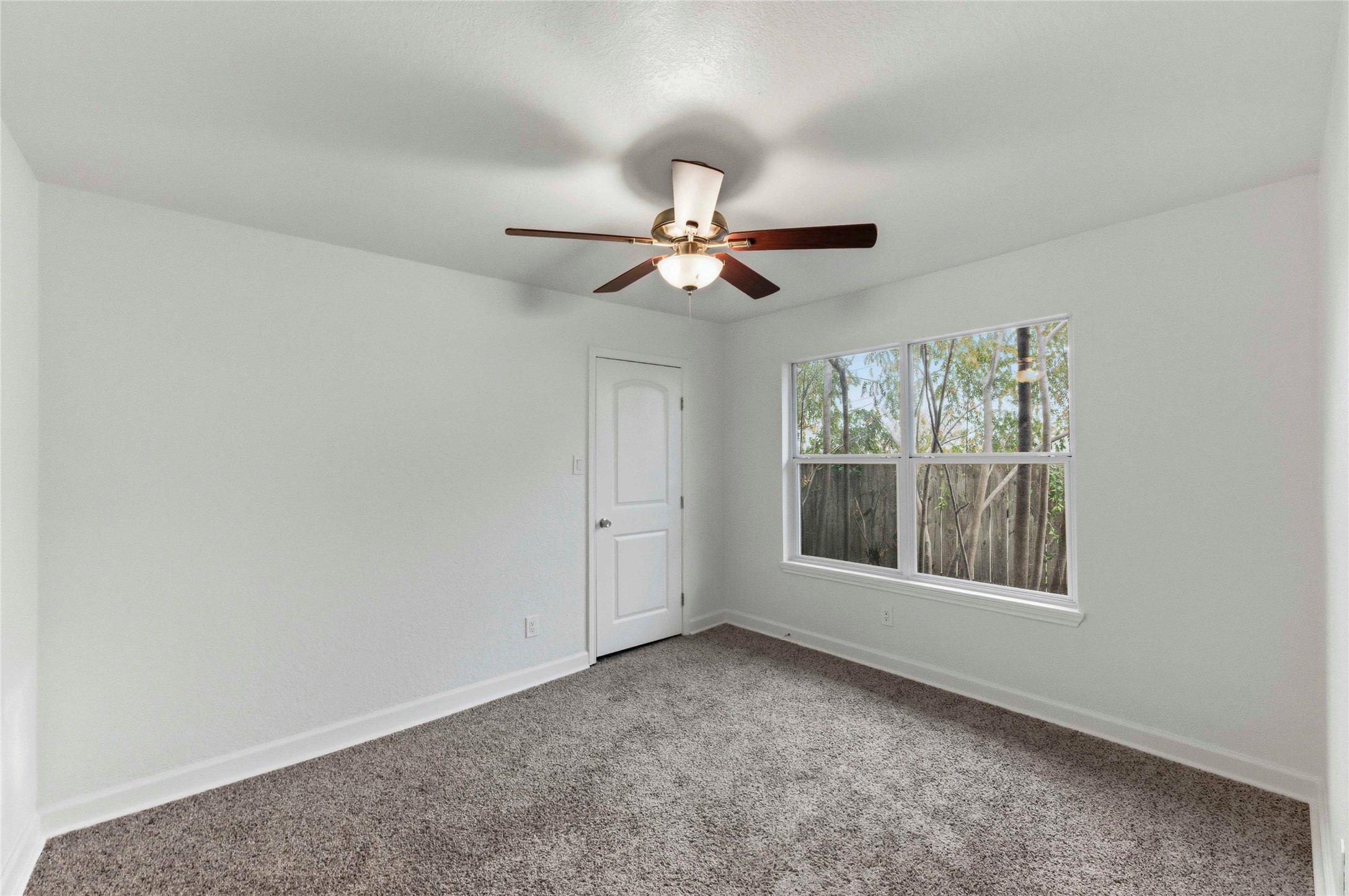 1909 Crooked Lane Austin, TX 78741 - Photo 21 of 25 Empty room featuring carpet and a ceiling fan