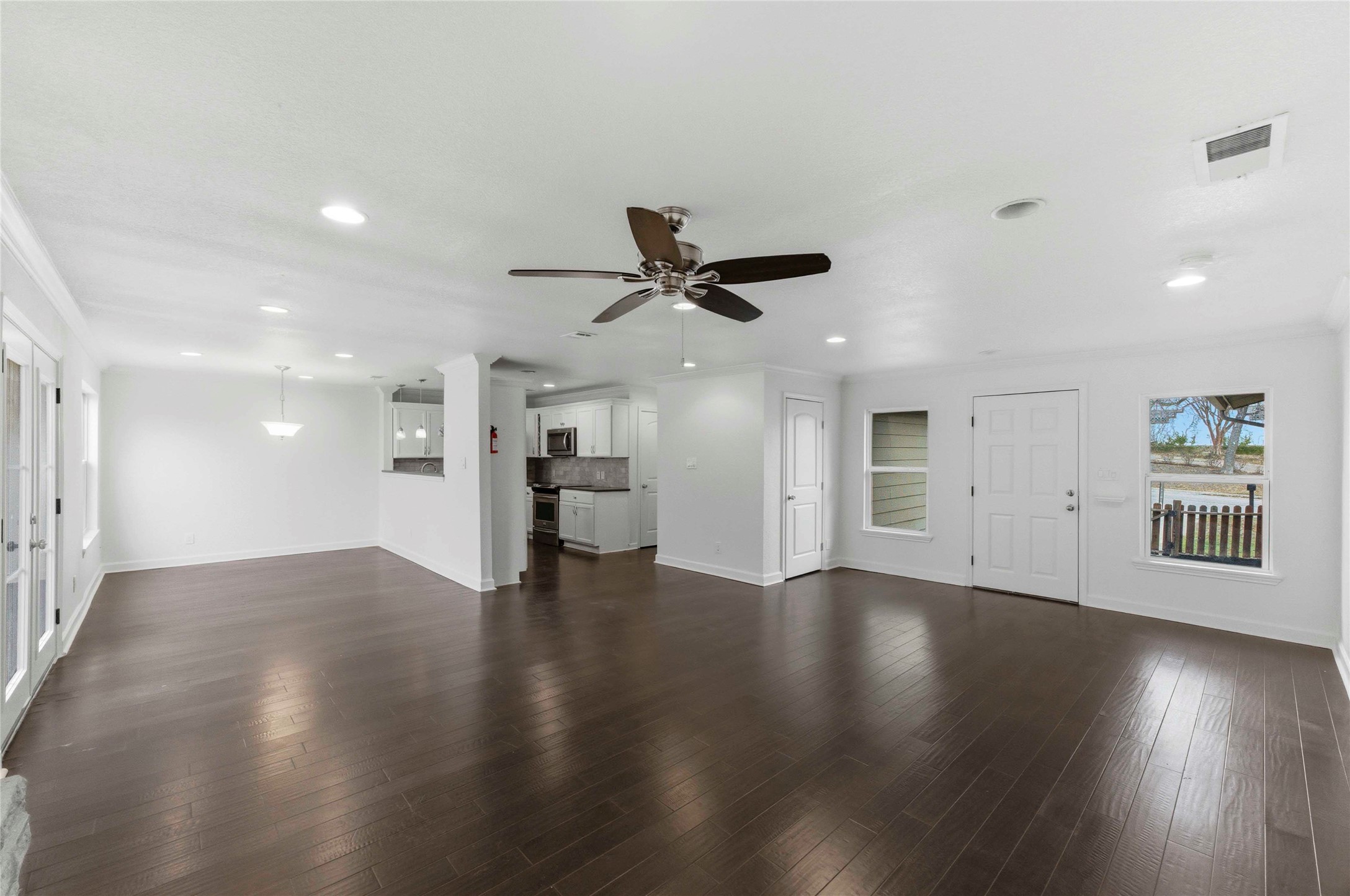 1909 Crooked Lane Austin, TX 78741 - Photo 6 of 25 Unfurnished living room featuring dark wood-style flooring, recessed lighting, and ceiling fan