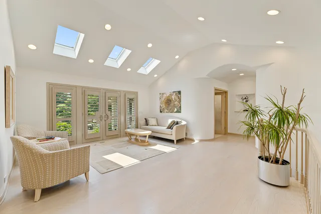 a spacious bedroom with a bed a couch and large window