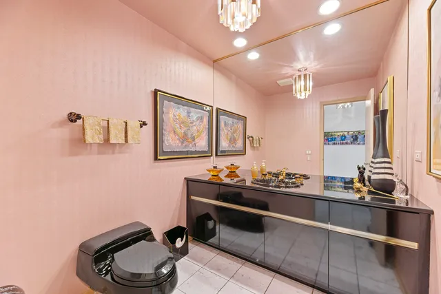 a spacious bedroom with a large bed and chandelier