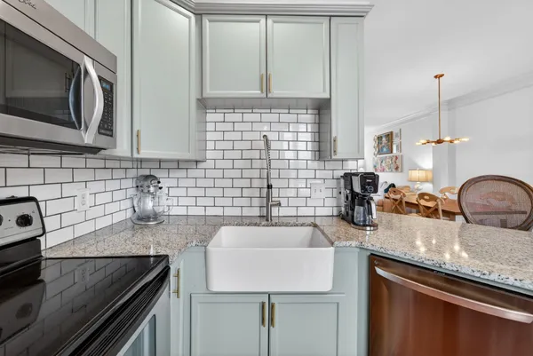 a kitchen with granite countertop a sink stainless steel appliances and cabinets