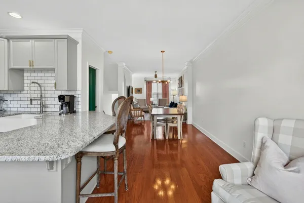 a kitchen with granite countertop a table chairs stove and kitchen island
