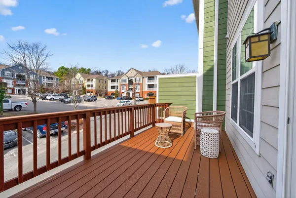 a balcony with wooden floor and outdoor seating