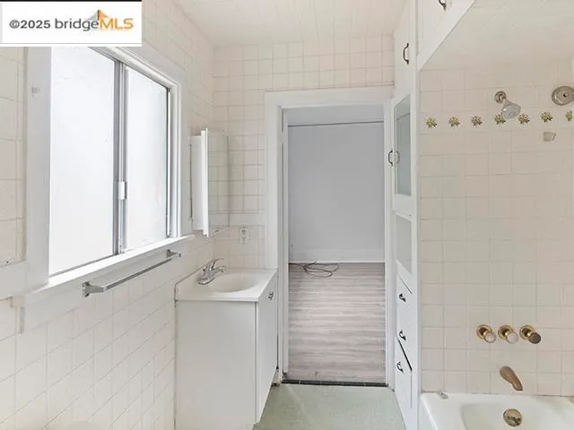a bathroom with a tub sink and mirror