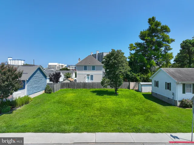 a aerial view of a house with a big yard plants and large tree