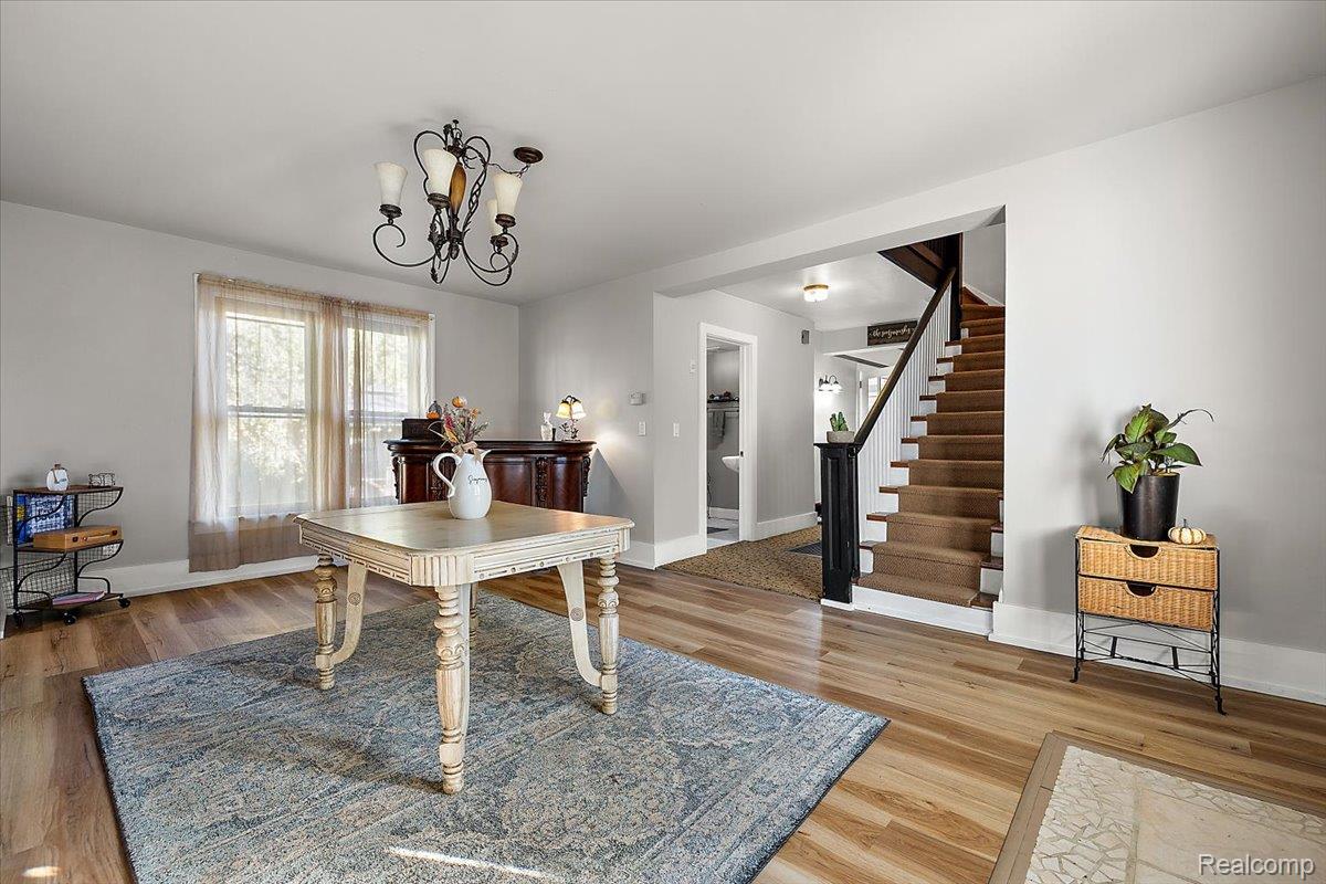 5815 Chicago Road Warren, MI 48092 - Photo 15 of 47 Dining area featuring stairs, light wood-style floors, and a chandelier