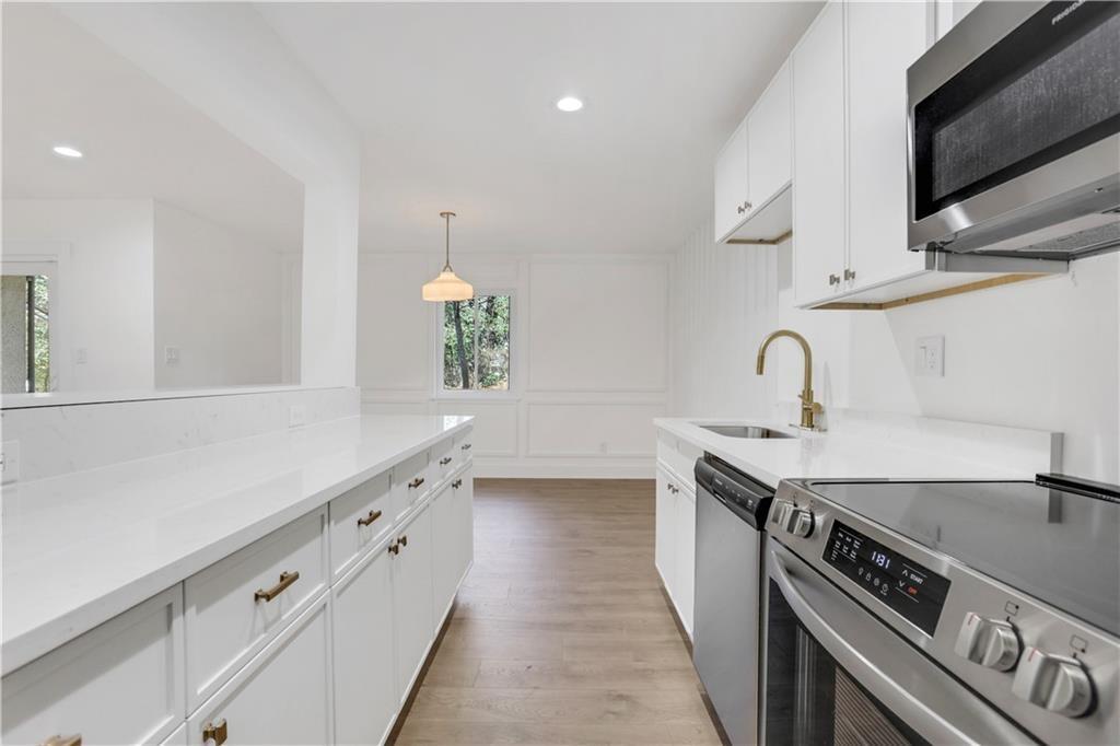 a kitchen with stainless steel appliances a sink stove and cabinets