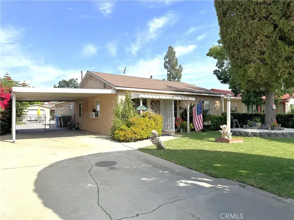 a front view of a house with a garden and trees