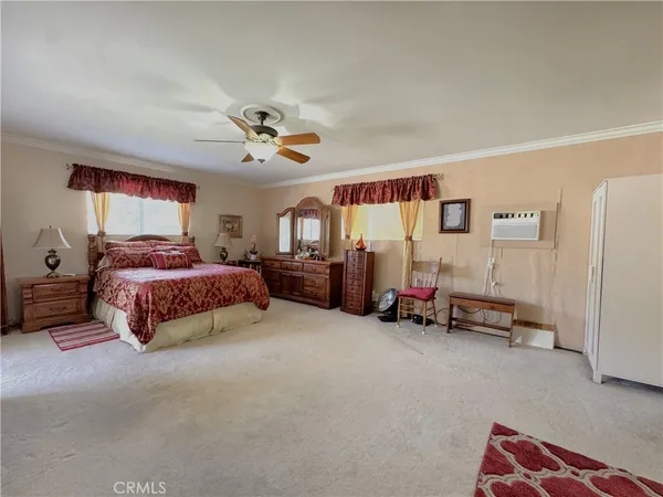 a spacious bedroom with a bed and a chandelier