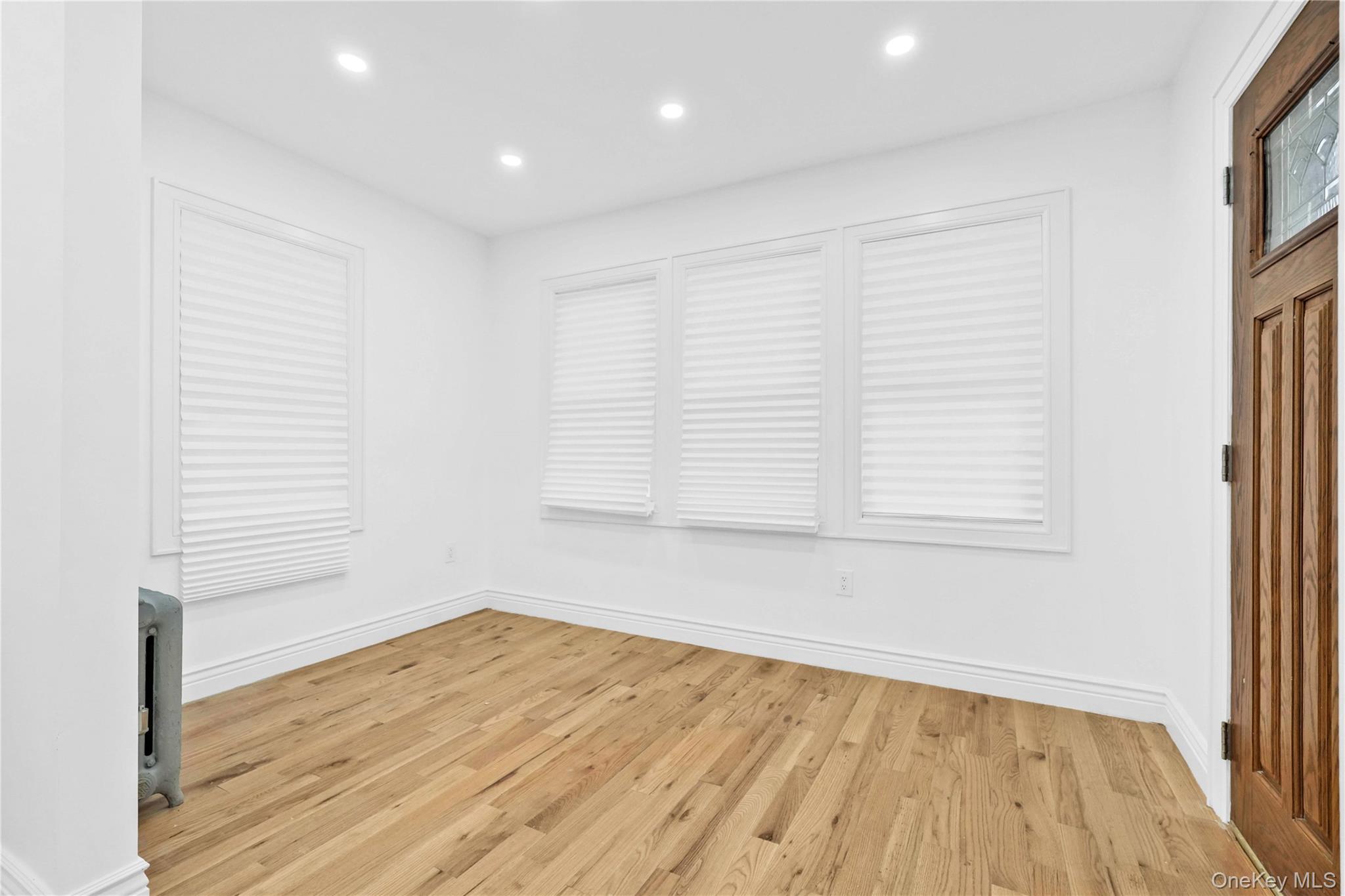 21432 112th Road Queens, NY 11429 - Photo 5 of 18 an empty room with wooden floor and windows