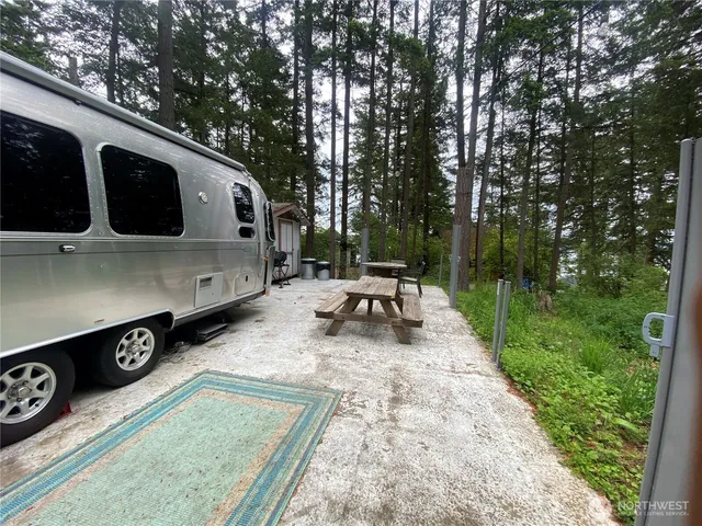 a backyard of a house with barbeque oven table and chairs